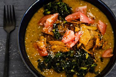 Sağlıklı bitkisel tarif kavramı, köri soslu sebze güveci lahana domatesleri ve torilla cipsi.