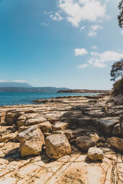 Güneşli bir yaz gününde Opossum Körfezi Plajı 'ndaki manzara. Koyu mavi suları ve açık gökyüzü olan sahilde güzel kıyı şeridini ve kıyılarını yükselten hiç kimse yok.