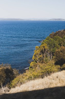 Hava kararmadan önceki güneşli bir yaz gününde Blackman Körfezi 'nden gelen su manzarası Hobart kenti yakınlarındaki en popüler plajlardan biridir.