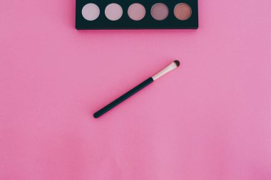 Güzellik endüstrisi ve kozmetik ürünleri natürmort, minimalist pembe arka plan ve kopyasal alan fırçalı göz falı paleti
