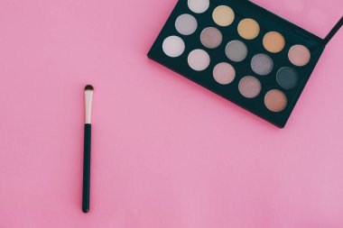 Güzellik endüstrisi ve kozmetik ürünleri natürmort, minimalist pembe arka plan ve kopyasal alan fırçalı göz falı paleti