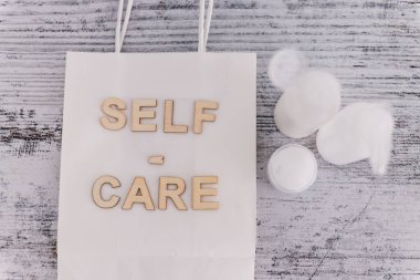 Cilt ürünleri, güzellik endüstrisi ve kaplıca ürünleri ile çevrili alışveriş poşetindeki kişisel bakım mesajı