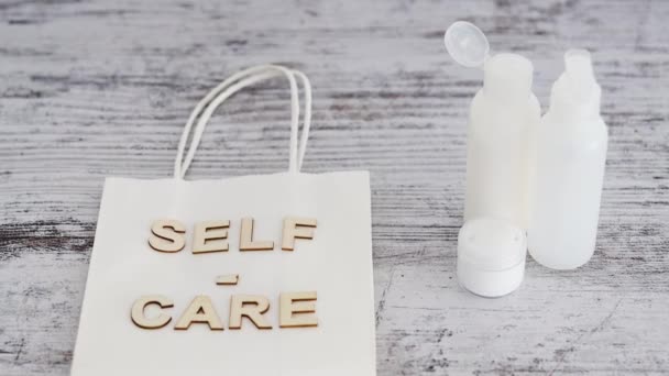 Self Care Botschaft Auf Einkaufstasche Umgeben Von Pflegeprodukten Und Kameraschwenk — Stockvideo