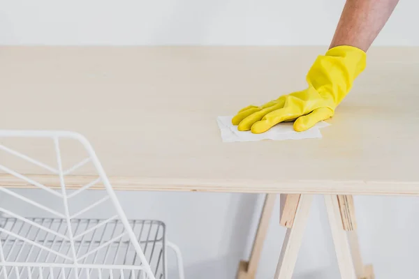 concept of disinfecting surfaces from bacteria or viruses sill-life, hand with glove cleaning table with disinfectant wet wipe