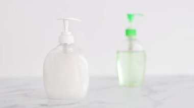Virüs ve bakterilere karşı hijyen, el dezenfektanı ve mermer banyoda sıvı sabun şişesi ve yatay çekim yapan kamera.