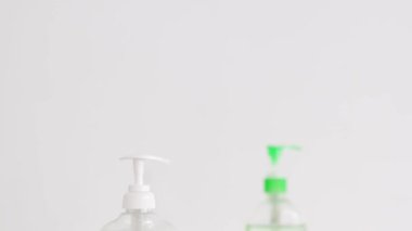 Virüs ve bakterilere karşı hijyen, el dezenfektanı ve mermer banyoda sıvı sabun şişesi ve dikey çekim yapan kamera.