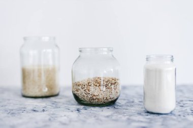 Vejetaryen kiler için sağlıklı bozulmaz gıda malzemeleri, yulaf unu ve pirinç dolu cam kavanozlar. 