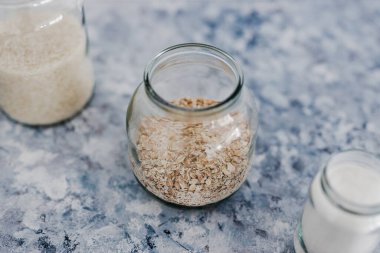 Vejetaryen kiler için sağlıklı bozulmaz gıda malzemeleri, yulaf unu ve pirinç dolu cam kavanozlar. 