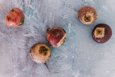 Vejetaryen yemekleri için sağlıklı malzemeler, taze çiğ pancar kökleri ve gri üzerinde yoğun mor renkler.