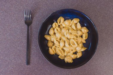 Sağlıklı bitkisel yemek tarifleri natürmort, sarımsak soslu kremalı vejetaryen kabuklu makarna.