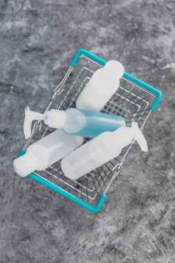 Hijyenin mikropların ve virüslerin yayılmasını yavaşlatması, temizlik malzemeleriyle dolu alışveriş sepeti ve eğriyi düzleştirmek için temizlik malzemeleri sembolü ve yüzey.