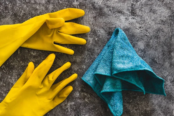 disinfecting and cleaning against bacteria and viruses conceptual still-life, yellow cleaning gloves and microfiber cloth on top of surface to be sanitized