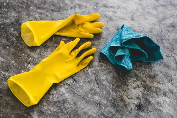 disinfecting and cleaning against bacteria and viruses conceptual still-life, yellow cleaning gloves and microfiber cloth on top of surface to be sanitized