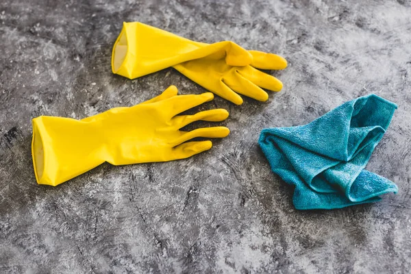 disinfecting and cleaning against bacteria and viruses conceptual still-life, yellow cleaning gloves and microfiber cloth on top of surface to be sanitized