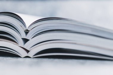 Eğitim ve kendini geliştirme konsepti, her öğreticinin üzerine yığılmış açık kitap yığını göz hizasından sığ alan derinliği ile çekilen