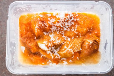 Taze üretim kavramının korunması, üzerinde buz olan plastik kabın içinde pişirilmiş ve dondurulmuş kayısılar.