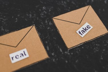 Güven-wrothy vs sahte e-postalar veya online dolandırıcılık konsepti, e-posta zarf simgeleri üzerinde gerçek vs sahte etiketler