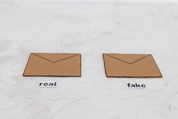 trust-wrothy vs fake emails or online scams concept, email envelop icons with real vs fake labels on them