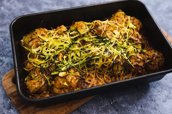 healthy plant-based food recipes concept, vegan roasted potato bake with spicy sauce and zucchini noodles topping