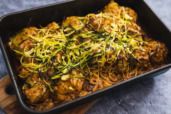 healthy plant-based food recipes concept, vegan roasted potato bake with spicy sauce and zucchini noodles topping