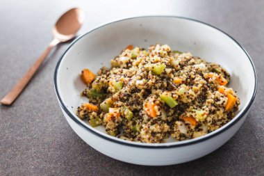 sağlıklı bitkisel yemek tarifleri konsepti, vejetaryen zencefilli kinoa salatası doğranmış kereviz soğanı ve havuç.