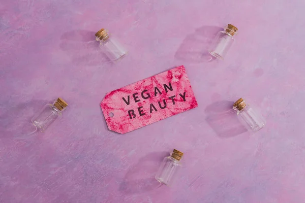 cruelty-free beauty products with no animal testing concept, group of essential oil bottles with Vegan Beauty message on label next to them