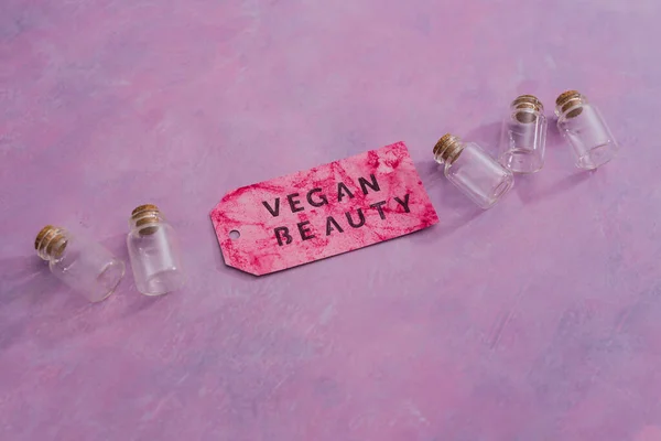 cruelty-free beauty products with no animal testing concept, group of essential oil bottles with Vegan Beauty message on label next to them