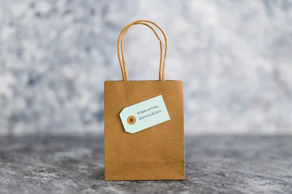 food shopping and home delivery of groceries concept, market bag with Essential Groceries label