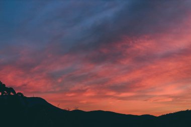 Tazmanya, Avustralya tepelerinde yuvarlanan güzel bulutlarla birlikte pembe gün batımı gökyüzü.