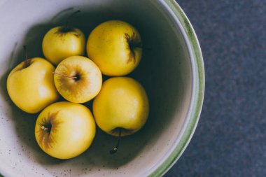 sağlıklı bitkisel malzemeler konsepti, bir grup altın lezzetli elma mutfak tezgahında kasede