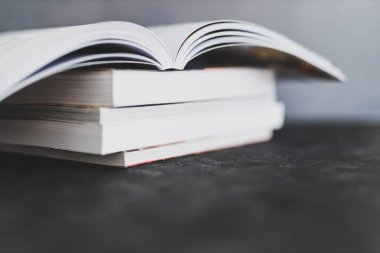 Eğitim ve kendini geliştirme, bir kitap yığını açık, göz hizasından sığ alan derinliğine sahip.