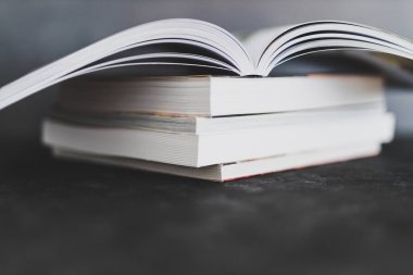 Eğitim ve kendini geliştirme, bir kitap yığını açık, göz hizasından sığ alan derinliğine sahip.