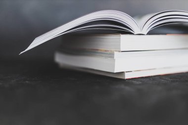 Eğitim ve kendini geliştirme, bir kitap yığını açık, göz hizasından sığ alan derinliğine sahip.