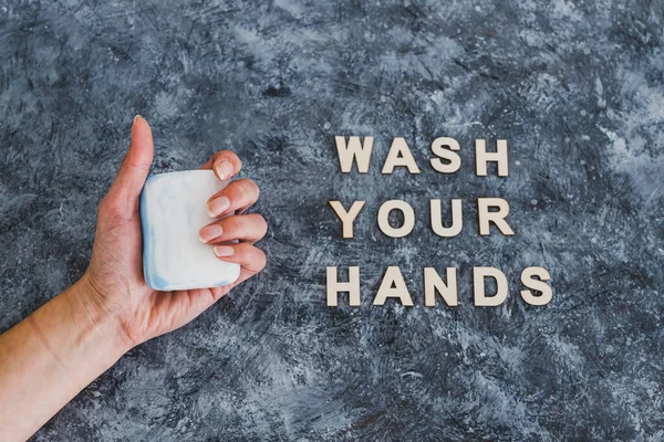 keep clean to fight bacteria and viruses, hand holding soap next to Wash your Hands text