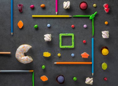 Pac Man bilgisayar oyununun kare çerçevesinde kırmızı çörek ve jöleli şekerlemelerle kurulumu