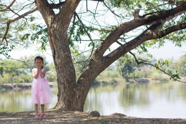 Ağaç lagoon yakınındaki küçük Asyalı kız