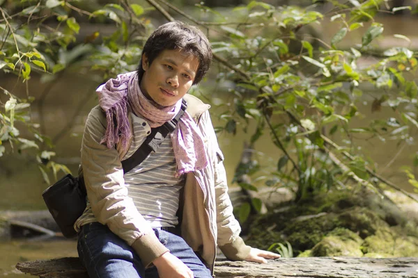 Vacante asia hombre sentado madera en río bosque —  Fotos de Stock
