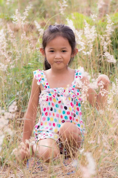 Thai girl in Grass flower field — Stock Photo, Image
