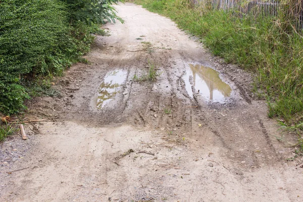 Dirty dirt road with puddles and mud in countryside in Thailand — Stock Photo, Image