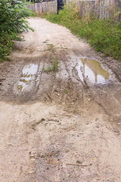 Dirty dirt road with puddles and mud in countryside in Thailand — Stock Photo, Image