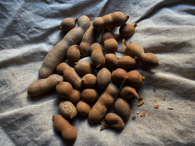  Olgun Tamarind meyveleri. Keten dokusunda kurutulmuş tatlı tamarindler.