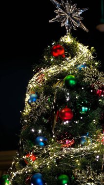 Noel ağacında bir sürü renkli süs. Mutlu Noeller ve mutlu tatiller. Noel için dekore edilmiş güzel bir oturma odası. Noel ağacıyla süslenmiş bir ev. Güzel süsler. 