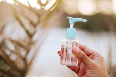 El jeli dezenfektanı cildindeki mikropları öldürür. Düzenli kullanım korona virüsünün yayılmasını engelleyecek. Fotoğraf dışarıda, güneş ışığı altında çekildi..