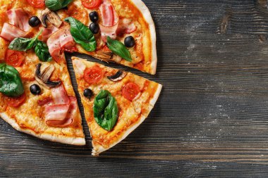 Mantarlı, fesleğenli, domatesli, zeytinli ve peynirli İtalyan Pizzası. Bir parça kes ve it. Koyu tahta masa arkaplanı. Prosciutto, Capricciosa, Funghi, Cotto PIZA olarak bakın. Reklam için ideal