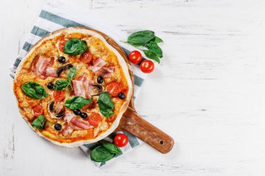 Mantar, fesleğen, domates, zeytin ve peynirli beyaz ahşap masada çok sıcak İtalyan pizzası. Prosciutto, Capricciosa, Funghi, Cotto Pizza 'yı dekore ederek evine götürdü. Metin için boşluğu olan fotoğraf. 
