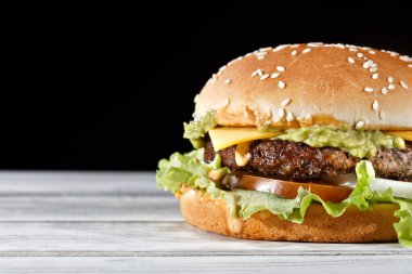 Avokado aromalı tek köfteli burger ve domatesle süslenmiş erimiş peynir, taze marul ve beyaz soğan. Teslimat isteğini karşılamak için mükemmel..