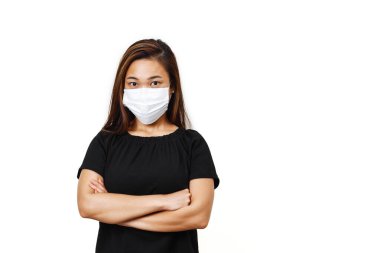 Düz beyaz arkaplan ve metin için boşluk. Koronavirüse karşı korunmak için yüz maskesi takan Asyalı kadın. Yarı vücut görünümlü genç bayan dik görünüyor. Çapraz elli Asyalı kadın.