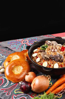 Özbek PILAF 'in düz yatağı. Ekmek ve sebzelerle süslenmiş geleneksel Özbek sofrası. Orta Asya konsepti