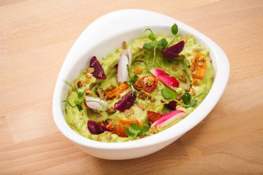 Granola domatesli organik bitki esaslı humus, taze kekik ve gül yaprağı soslu. Glütensiz vejetaryen yemeği için mükemmel..