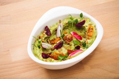 Granola domatesli organik bitki esaslı humus, taze kekik ve gül yaprağı soslu. Glütensiz vejetaryen yemeği için mükemmel. Yemek fotoğrafçılığı.